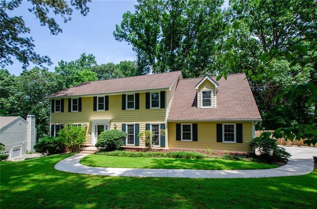 colonial inspired home featuring a front lawn