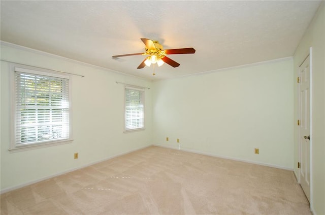 carpeted spare room with crown molding and ceiling fan