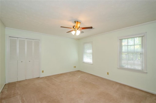 unfurnished bedroom with crown molding, light carpet, and multiple windows