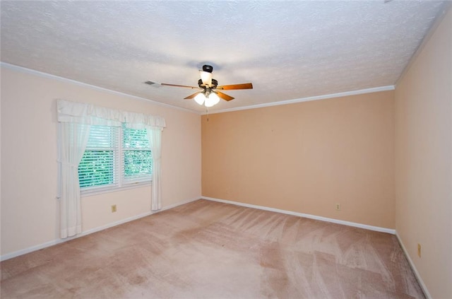 carpeted spare room featuring ceiling fan, ornamental molding, and a textured ceiling