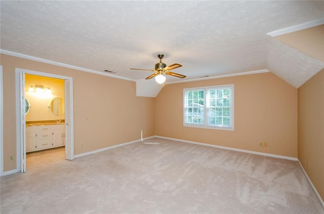 additional living space featuring ceiling fan, lofted ceiling, light carpet, and a textured ceiling