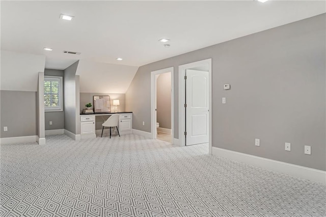 2444 Ballantrae Cir, Cumming, GA 30041 - living room with light colored carpet, visible vents, vaulted ceiling, built in desk, and baseboards