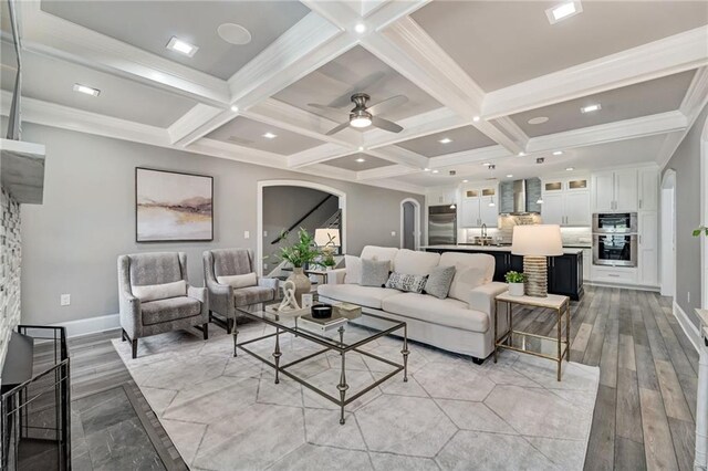 2444 Ballantrae Cir, Cumming, GA 30041 - living room with arched walkways, coffered ceiling, and light wood-type flooring