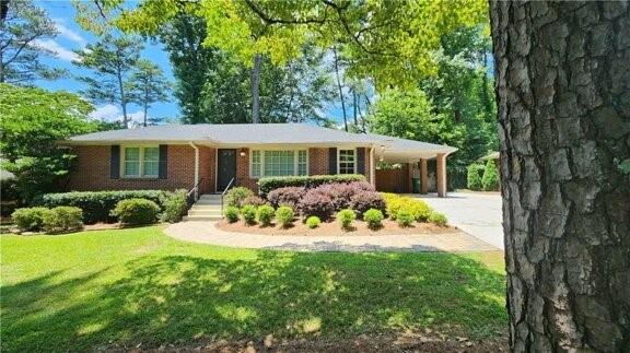 2132 Clairmont Rd, Brookhaven, GA 30033 - ranch-style house featuring a carport, concrete driveway, a front lawn, and brick siding
