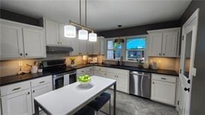 2132 Clairmont Rd, Brookhaven, GA 30033 - kitchen with concrete flooring, under cabinet range hood, pendant lighting, dark countertops, and appliances with stainless steel finishes