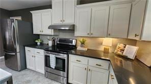 2132 Clairmont Rd, Brookhaven, GA 30033 - kitchen with white cabinetry, stainless steel range with electric stovetop, dark countertops, and under cabinet range hood