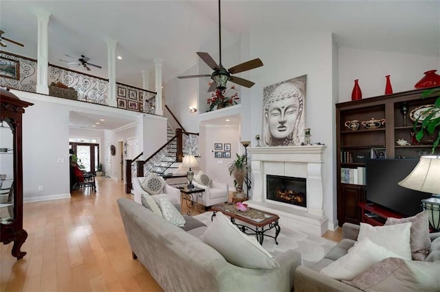 825 Chalet Hls, Mcdonough, GA 30253 - living area with a ceiling fan, high vaulted ceiling, stairs, a glass covered fireplace, and wood finished floors