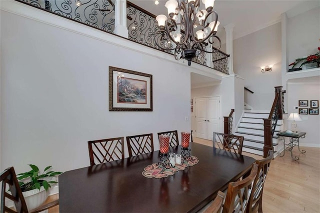 825 Chalet Hls, Mcdonough, GA 30253 - dining area featuring a towering ceiling, a chandelier, wood finished floors, stairs, and ornamental molding