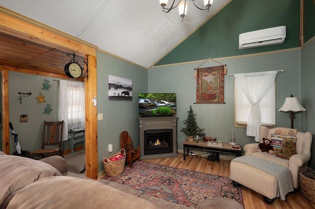 living area with vaulted ceiling, a warm lit fireplace, wood finished floors, and a wall mounted air conditioner