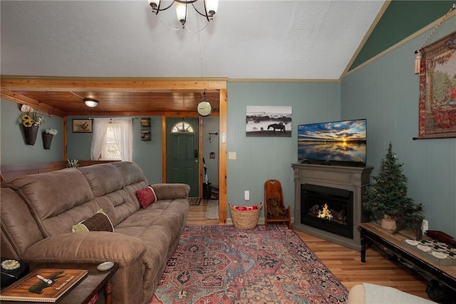 living area featuring wood finished floors, a warm lit fireplace, and a chandelier