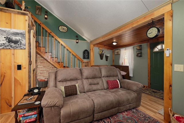 living area featuring stairs, lofted ceiling, and wood finished floors