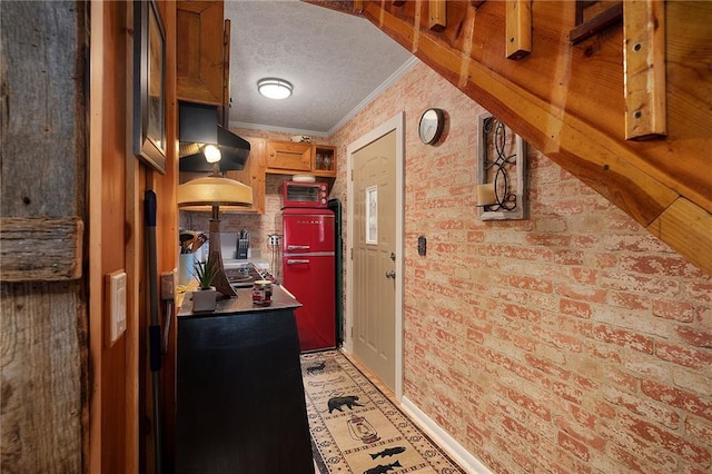 kitchen with brick wall, open shelves, a textured ceiling, crown molding, and exhaust hood