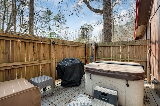 wooden terrace featuring area for grilling and a fenced backyard