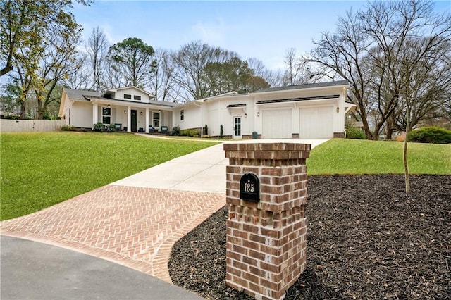 view of front facade featuring covered porch, a front lawn, decorative driveway, and an attached garage