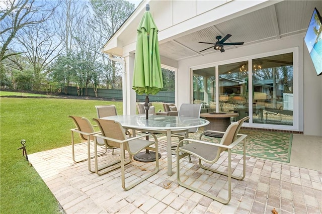 view of patio with outdoor dining space, fence, and ceiling fan