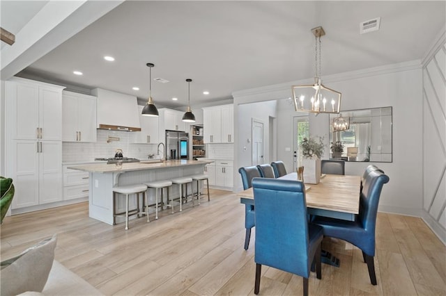 dining room featuring visible vents, crown molding, light wood-style floors, a notable chandelier, and recessed lighting