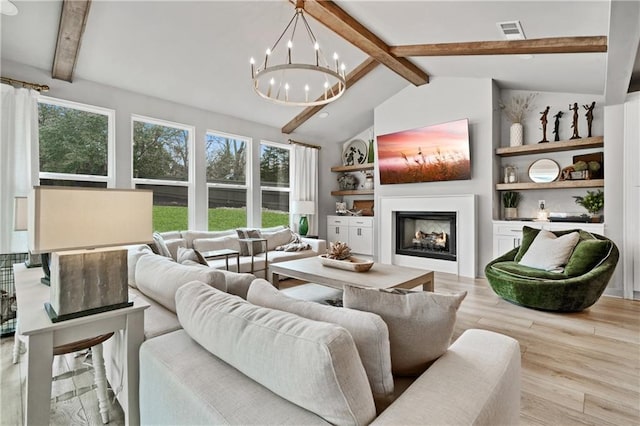 living room featuring a warm lit fireplace, a wealth of natural light, wood finished floors, and visible vents