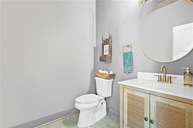 bathroom featuring toilet, tile patterned flooring, baseboards, and vanity