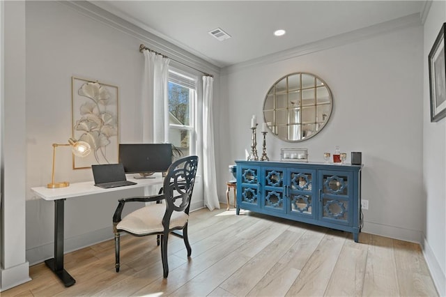 office area with visible vents, crown molding, baseboards, and wood finished floors