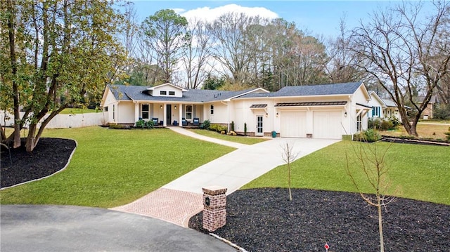 view of front facade with a porch, a garage, fence, driveway, and a front yard