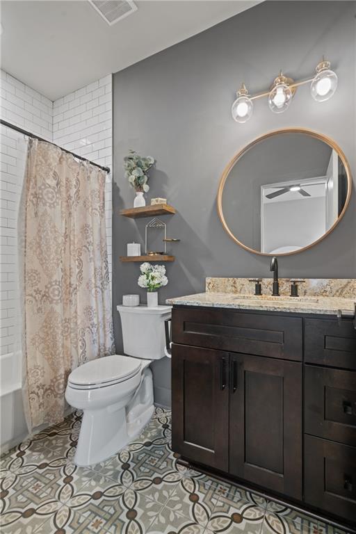 bathroom featuring toilet, visible vents, vanity, tile patterned floors, and shower / bath combo