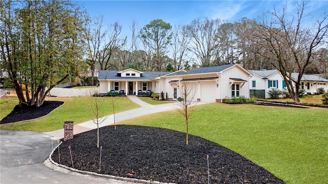 view of front of property featuring concrete driveway, a front lawn, board and batten siding, and an attached garage