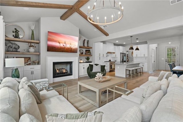 living area featuring light wood-type flooring, visible vents, vaulted ceiling with beams, and a lit fireplace