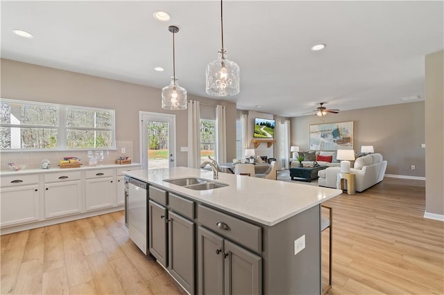 kitchen featuring sink, dishwasher, ceiling fan, pendant lighting, and white cabinets