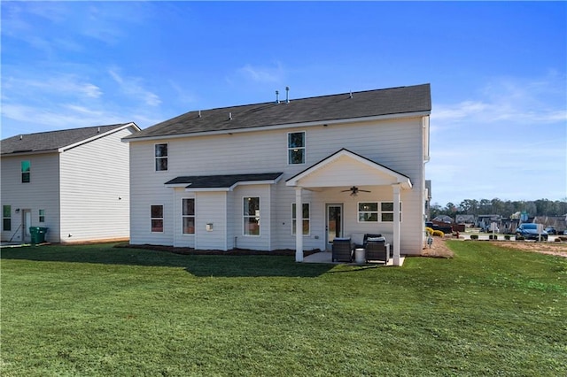 back of property featuring ceiling fan, a lawn, and a patio area