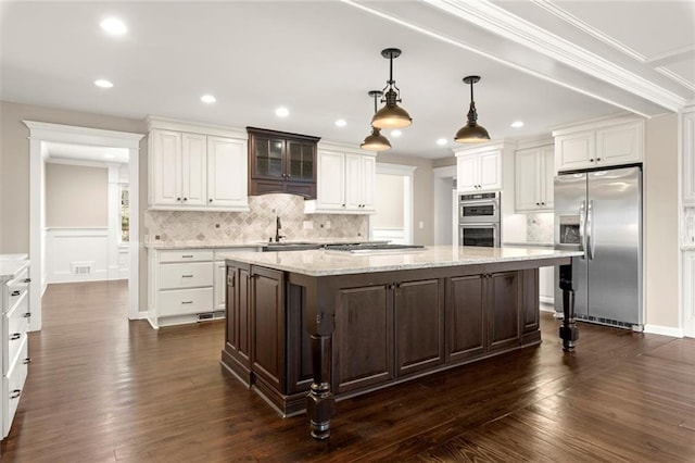 kitchen with stainless steel appliances, dark wood-style flooring, white cabinets, and a center island