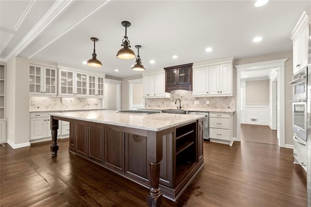 kitchen featuring a large island, white cabinets, dark wood-style floors, and a sink