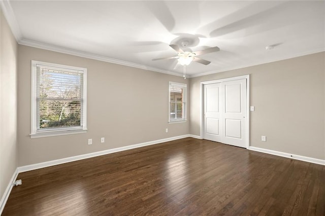 unfurnished bedroom with a closet, crown molding, baseboards, and dark wood-style flooring