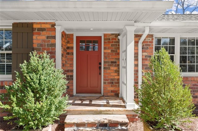 doorway to property featuring brick siding