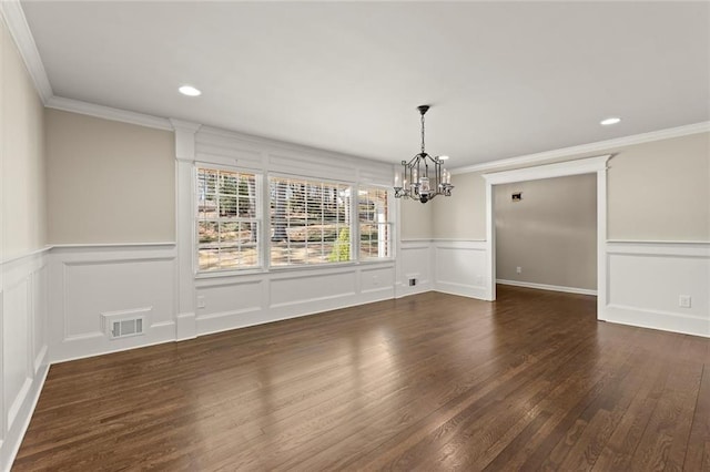 unfurnished room with visible vents, ornamental molding, wood finished floors, recessed lighting, and a decorative wall