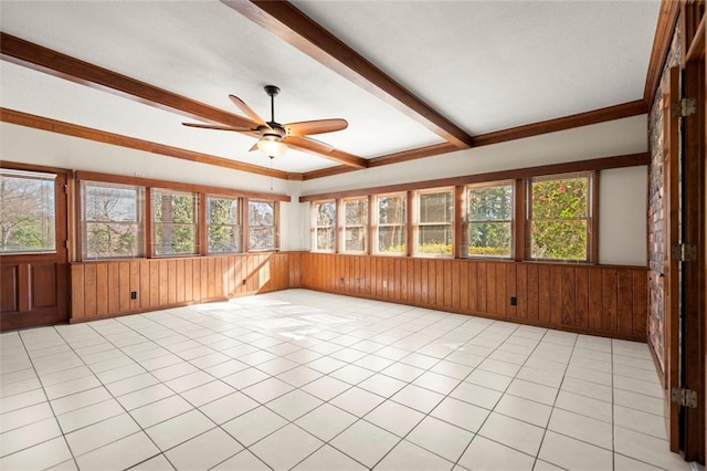 unfurnished sunroom with beamed ceiling, a healthy amount of sunlight, and a ceiling fan