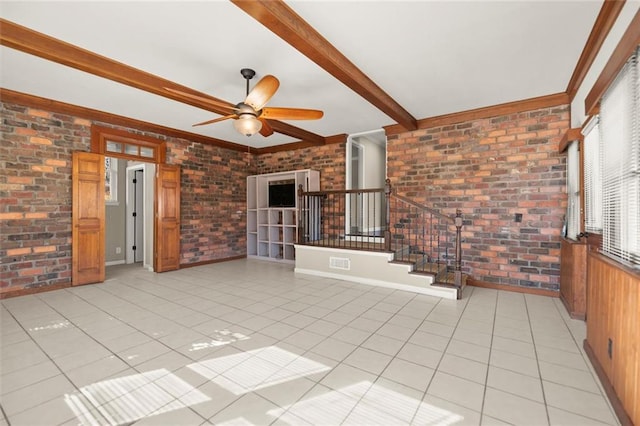 unfurnished room featuring light tile patterned floors, beamed ceiling, brick wall, and stairway