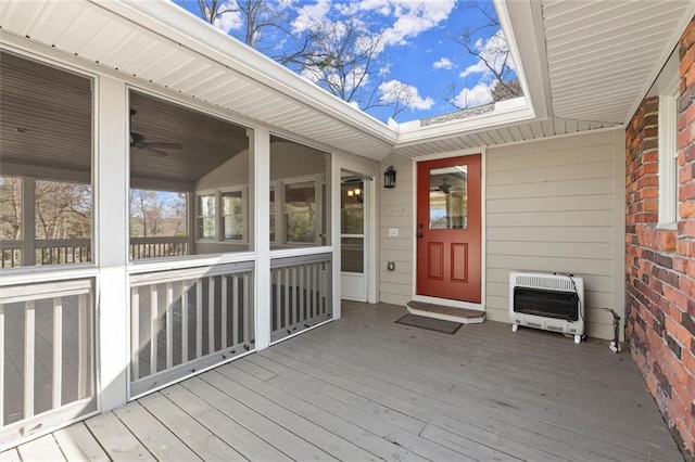 wooden terrace featuring heating unit and a sunroom