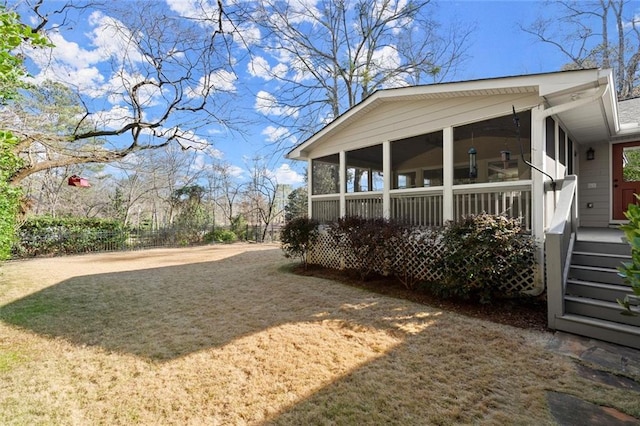 view of yard featuring driveway and a sunroom