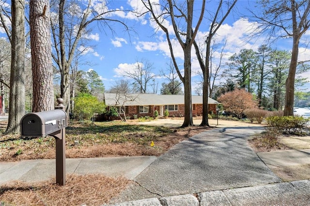 view of front of property featuring brick siding and driveway