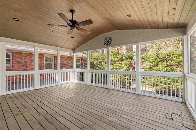 unfurnished sunroom featuring wood ceiling, a ceiling fan, and vaulted ceiling