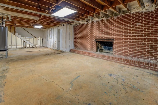 basement with water heater, brick wall, and a brick fireplace