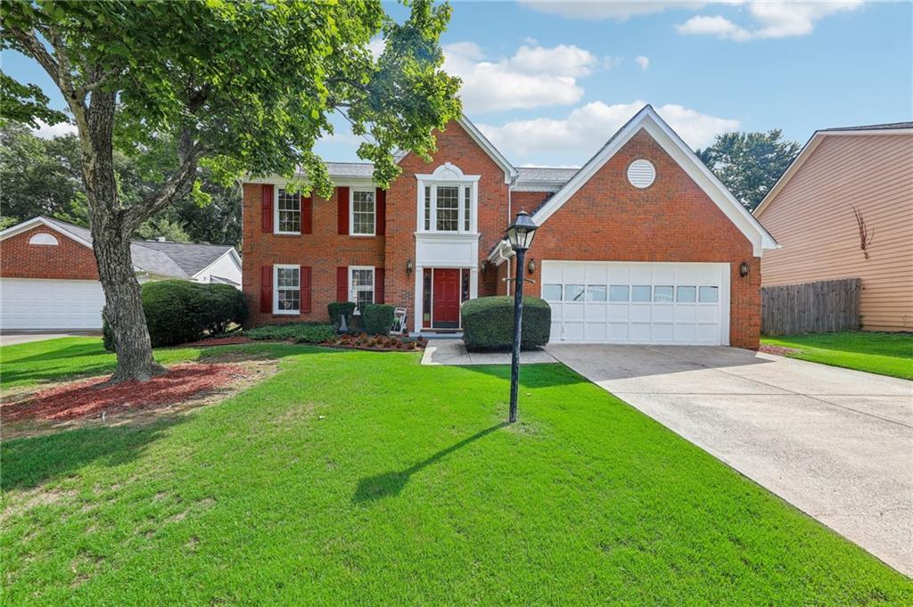 view of front of property featuring a garage and a front lawn