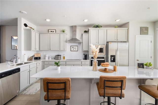 110 Cobalt Dr, Fayetteville, GA 30214 - kitchen featuring wall chimney range hood, sink, a kitchen breakfast bar, stainless steel appliances, and a center island