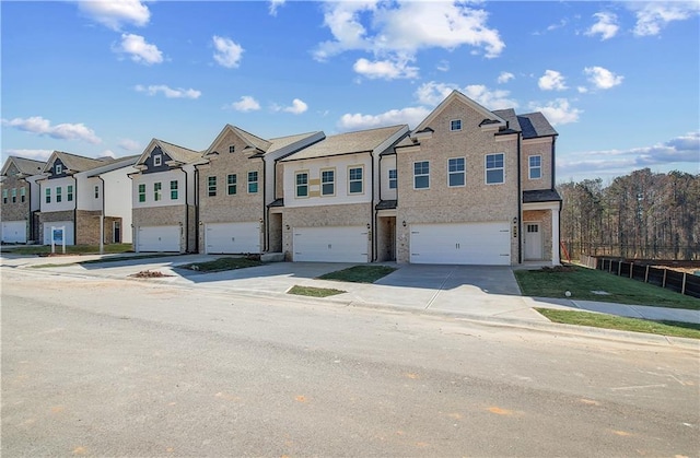 view of property featuring a garage, a residential view, and concrete driveway