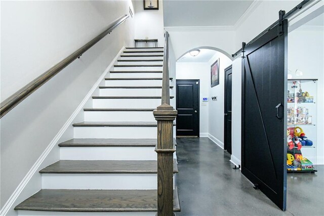 538 Micayne Cir Unit 3, Smyrna, GA 30082 - staircase featuring concrete floors, a barn door, baseboards, crown molding, and arched walkways