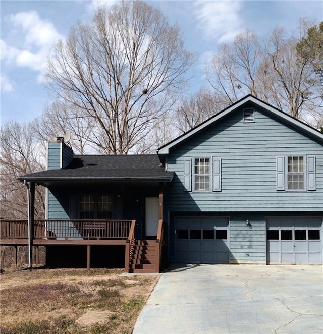 split level home with driveway, a chimney, and a garage