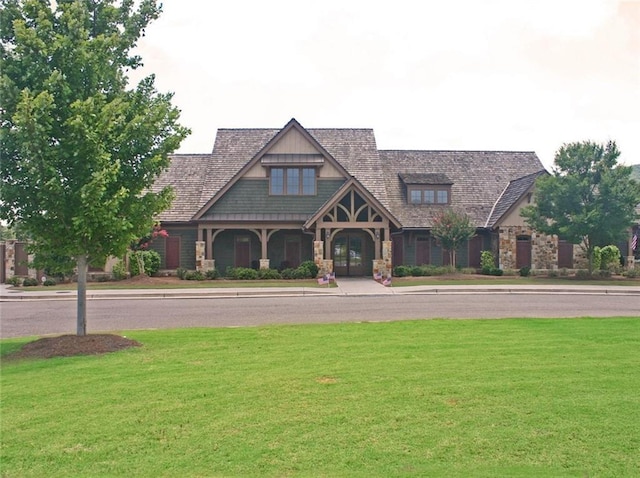 craftsman-style home with stone siding and a front lawn