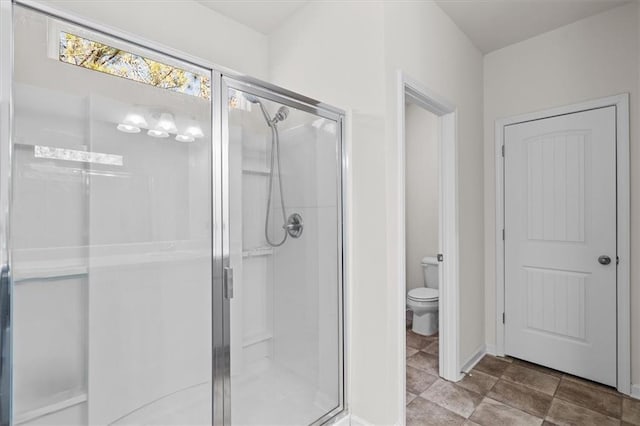 bathroom with a shower with door and toilet