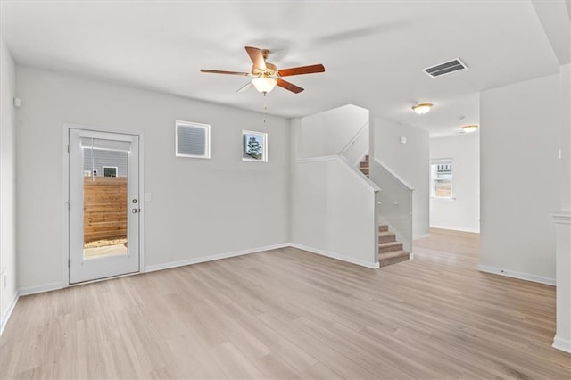 empty room with ceiling fan and light hardwood / wood-style flooring