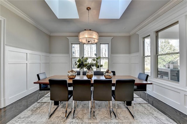 dining space with a skylight, plenty of natural light, and ornamental molding